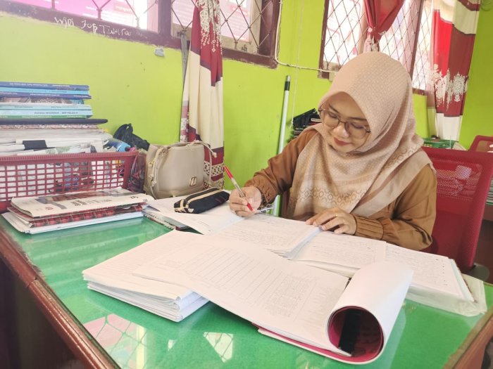 Ibu Suyatmi, S.Pd. Teliti Koreksi Hasil Ujian MID Semester Ganjil Bahasa Indonesia