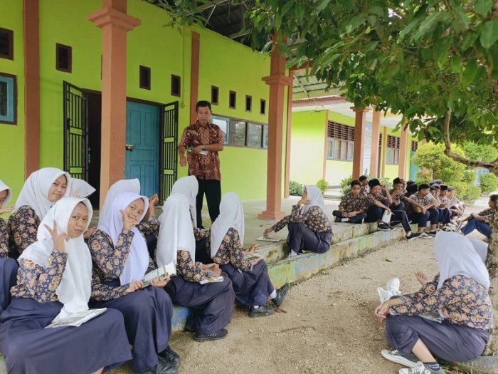 Santai dan Menyenangkan : Pak Tugiman Ajak Siswa Belajar Informatika di Teras Laboratorium Santai dan Menyenangkan : Pak Tugiman Ajak Siswa Belajar Informatika di Teras Laboratorium